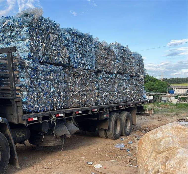 Caminhão sendo carregado com fardos de PET no pátio